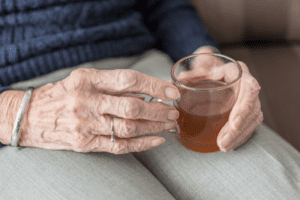 Hands of senior age woman with cup of tea